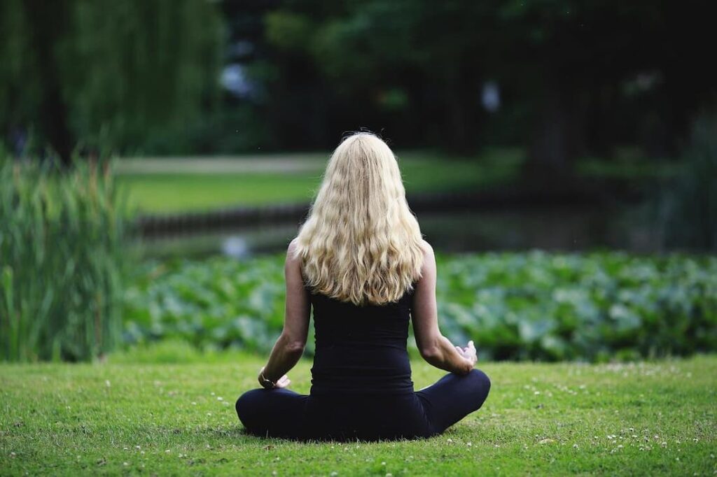 Persona meditando al aire libre, reflejando cómo acumular experiencias positivas con tu psicóloga en Marbella.