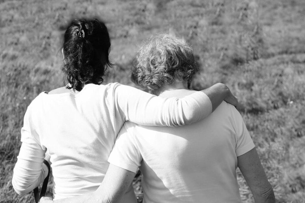 Dos personas caminando juntas abrazadas, reflejando la validación emocional guiada por tu psicóloga en Marbella.