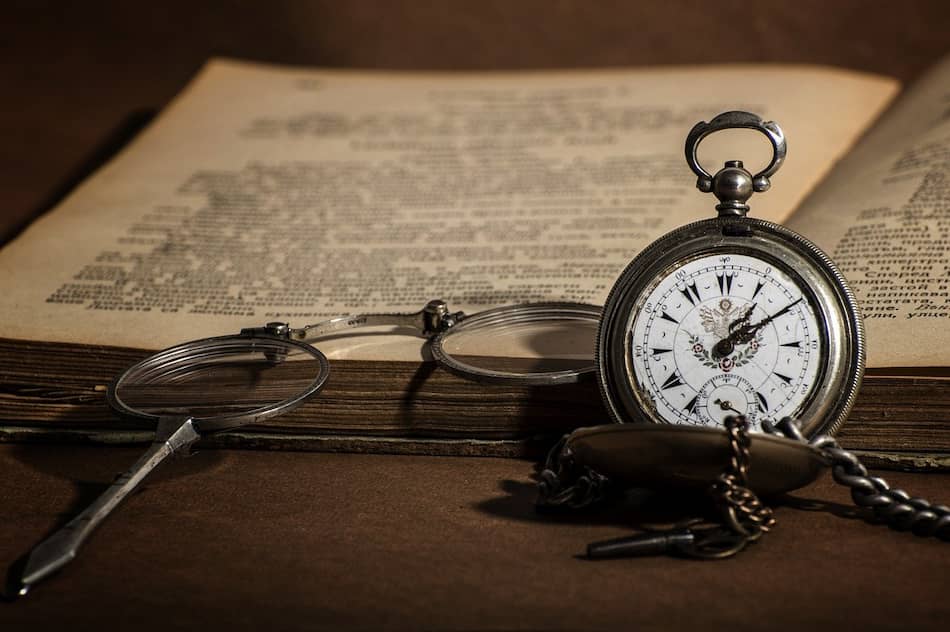 Reloj y libro antiguo sobre la mesa, simbolizando la reflexión y los aprendizajes de tu terapia en Marbella.