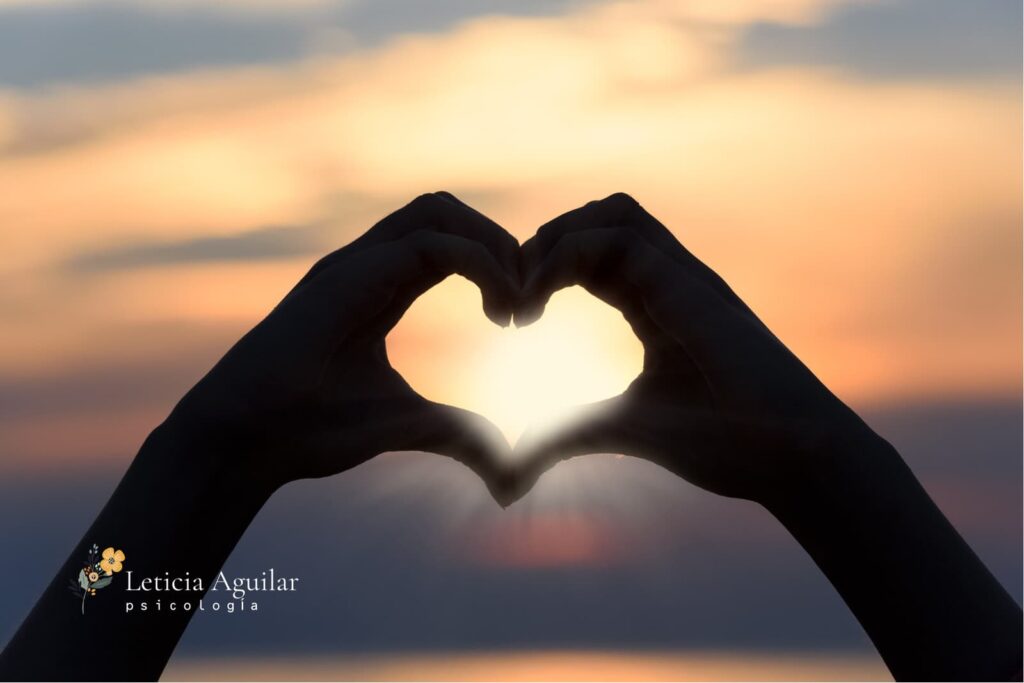Manos formando un corazón al atardecer, simbolizando el autocuidado y la psicóloga en Marbella en San Valentín.