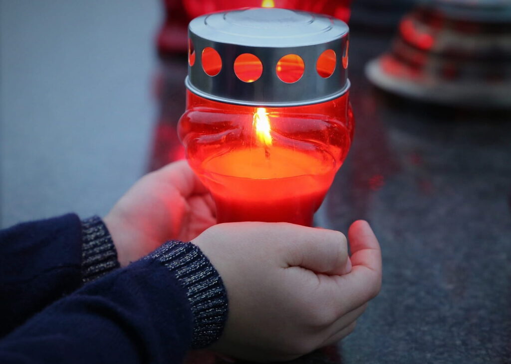 Manos sosteniendo una vela encendida, símbolo de esperanza y prevención del suicidio con ayuda psicológica en Marbella.