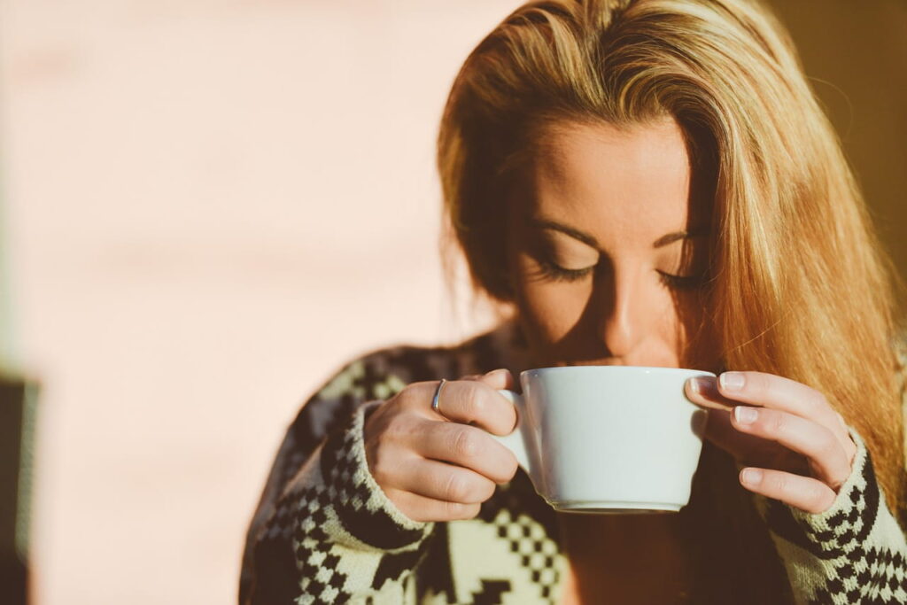 Mujer bebiendo café relajada, metáfora de relaciones sanas trabajadas con una terapeuta emocional en Marbella.