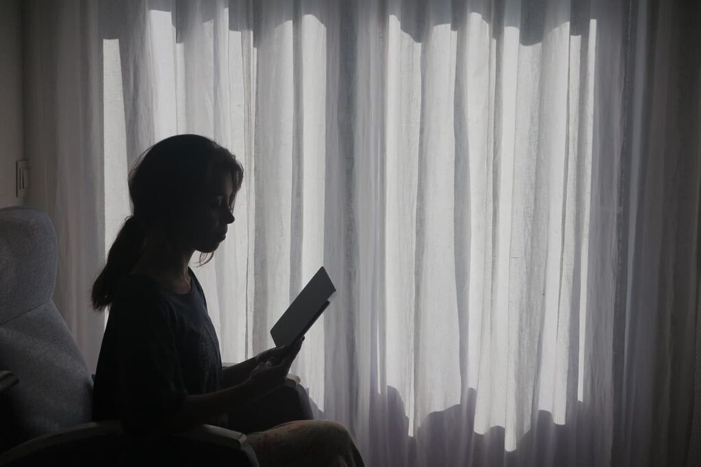 Silueta de mujer introspectiva junto a la ventana, buscando respuestas sobre psicología clínica y regulación emocional.