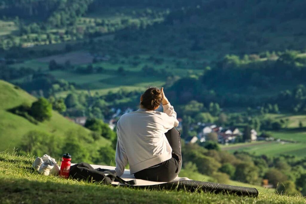 Persona descansando en la naturaleza, reflejando el autocuidado del psicólogo y terapeuta en Marbella.