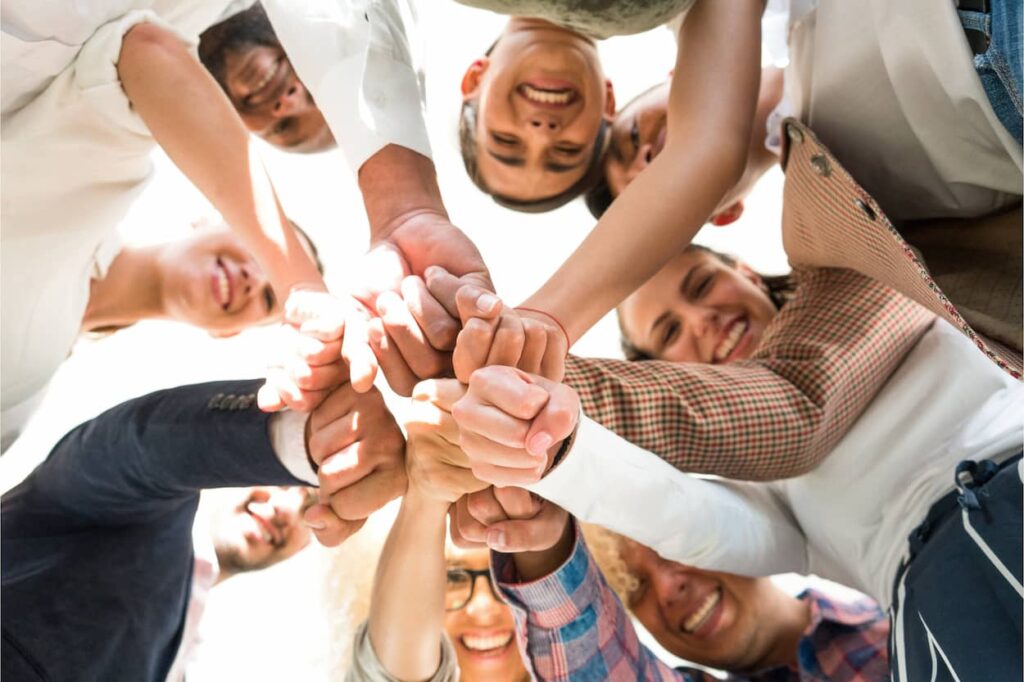 Grupo de personas unidas mostrando apoyo mutuo y mejora en las relaciones interpersonales.